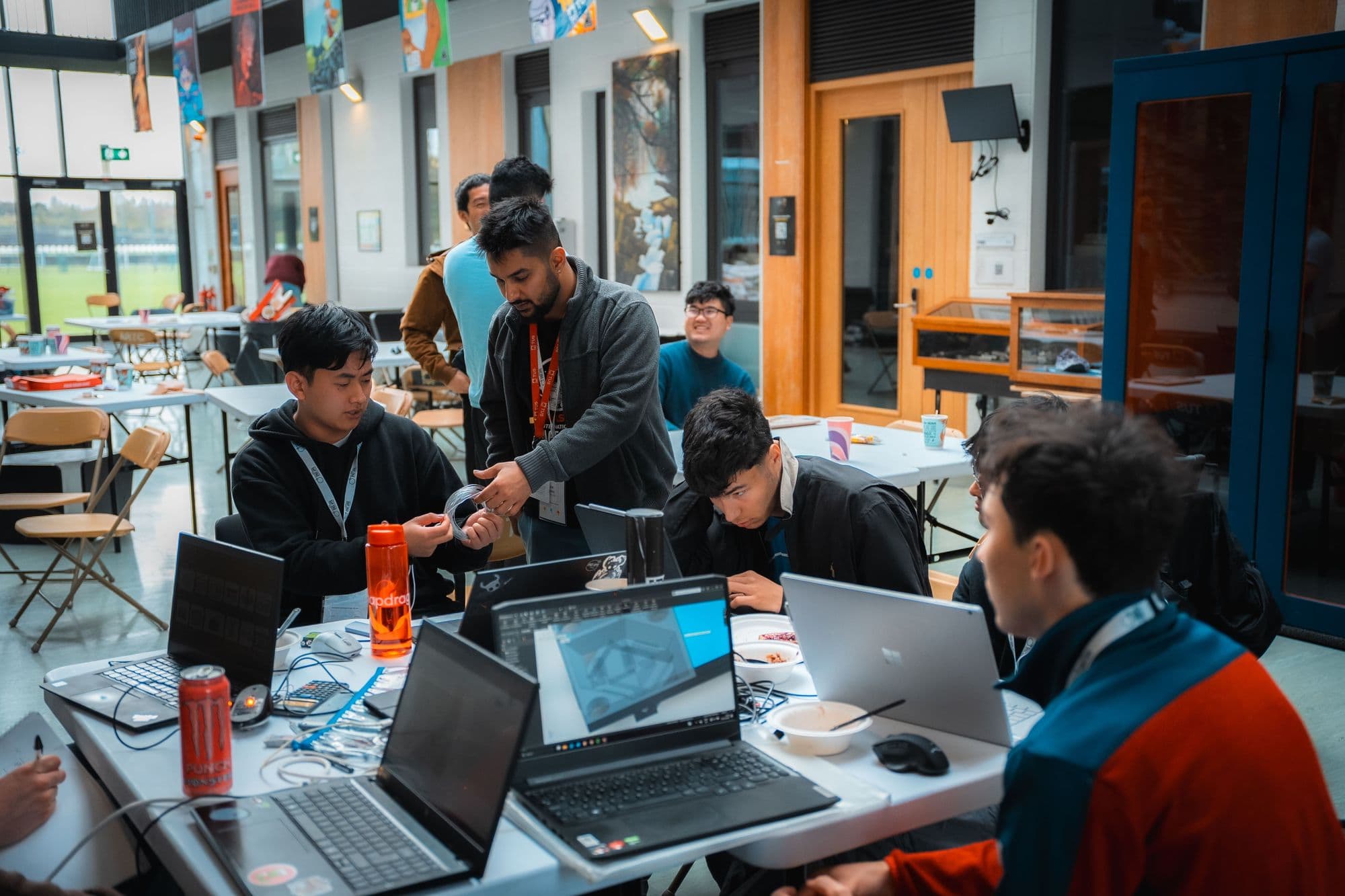 A team working together around laptops and hardware on the Saturday of the hackathon