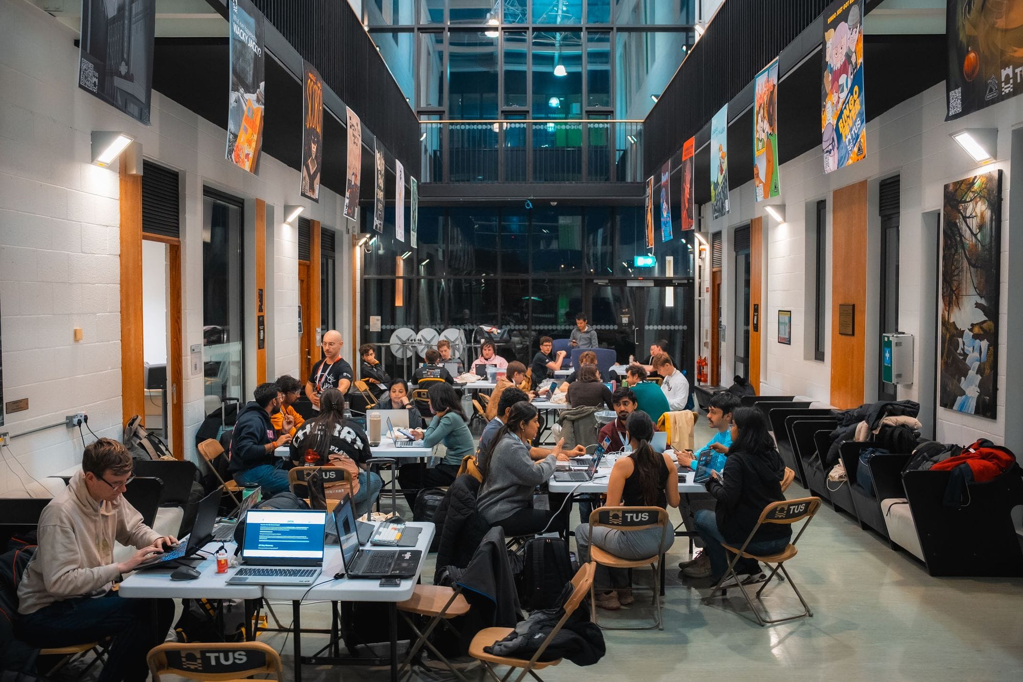 Teams working on laptops at long tables in the Engineering Building atrium at TUS Athlone
