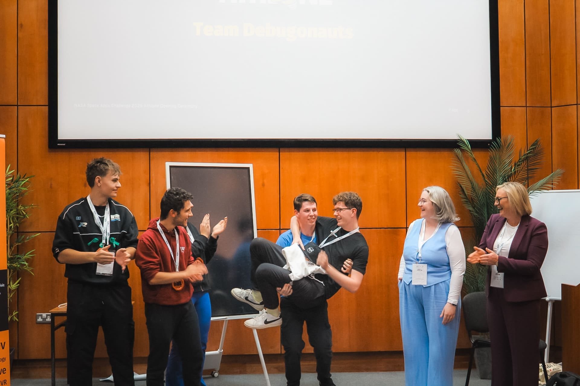 Team Debugonauts celebrating on stage at the HackAthlone 2025 awards as two presenters applaud