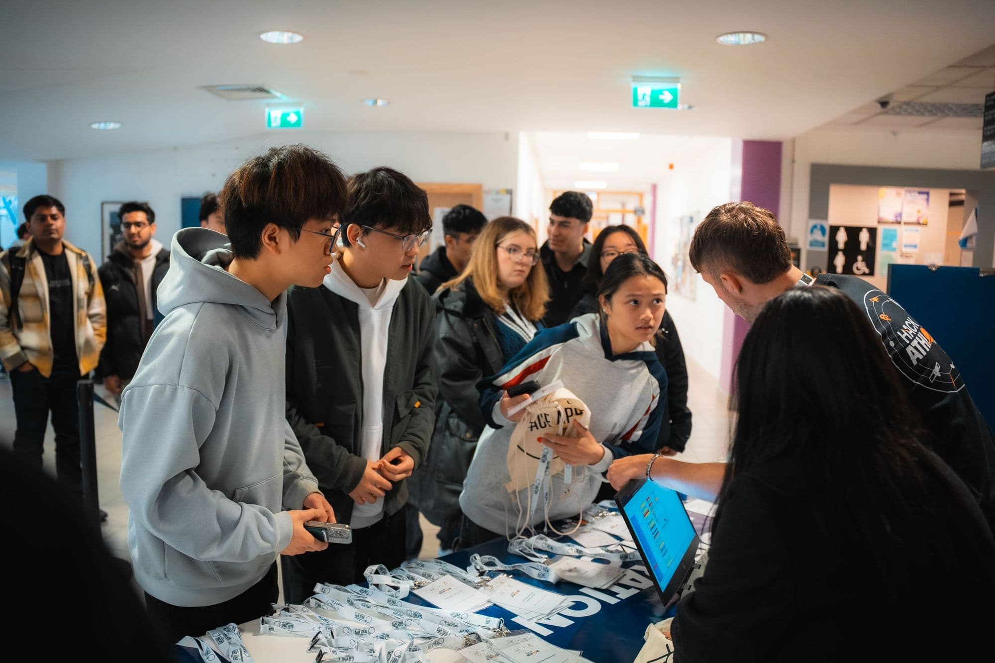 Participants collecting lanyards and T-shirts at the HackAthlone 2025 registration desk